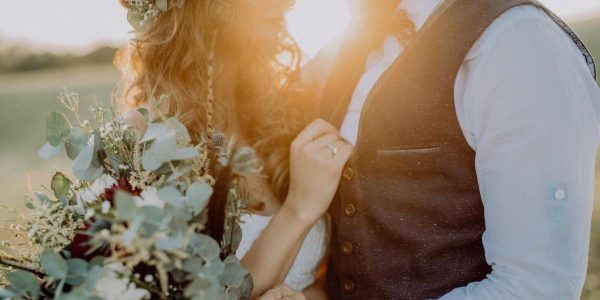 A photo of a married couple posing for a photo, only showing half of their faces.