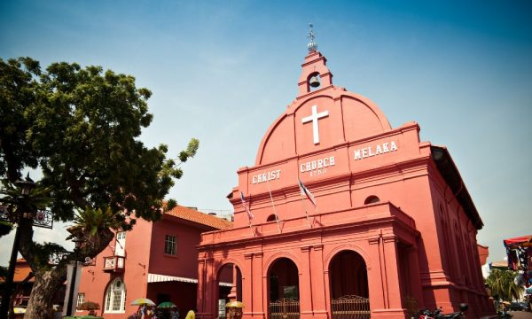 Low angle of Melaka's Christ Church with a tree on the left side of the photo.